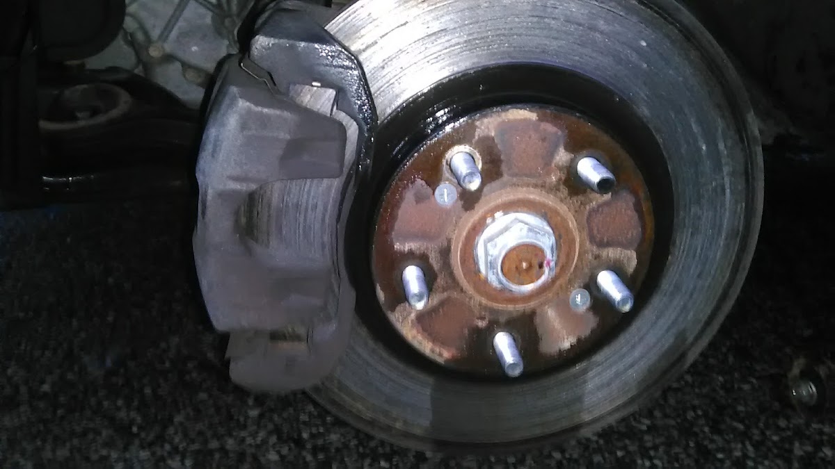 Close-up of a brake rotor and caliper mid-repair